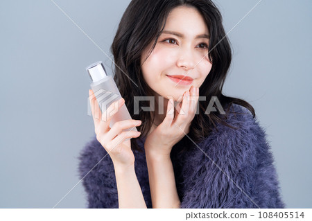 A middle-aged woman doing skin care against a gray background A middle-aged woman doing skin care against a gray background 108405514