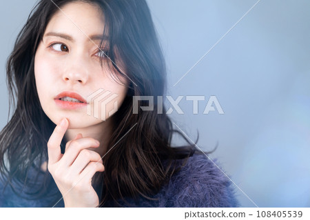 A middle-aged woman doing skin care against a gray background A middle-aged woman doing skin care against a gray background 108405539