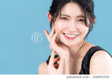 Middle-aged woman doing skin care with blue background 108405550