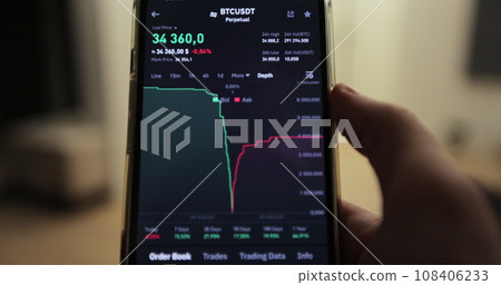 Man is looking at bitcoin price deapth chart on digital exchange on mobile phone screen, cryptocurrency. 108406233