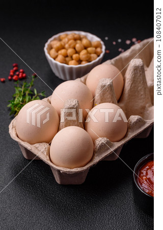 Raw chicken eggs in a box, cherry tomatoes, chickpeas, spices, salt and herbs Raw chicken eggs in a box, cherry tomatoes, chickpeas, spices, salt and herbs 108407012