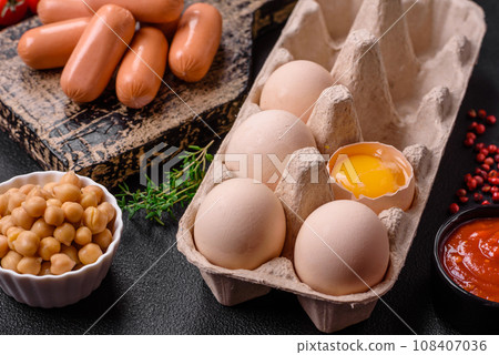 Raw chicken eggs in a box, cherry tomatoes, chickpeas, spices, salt and herbs Raw chicken eggs in a box, cherry tomatoes, chickpeas, spices, salt and herbs 108407036