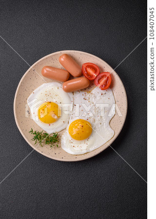 Fried chicken eggs, sausages, cherry tomatoes, chickpeas, spices, salt and herbs 108407045