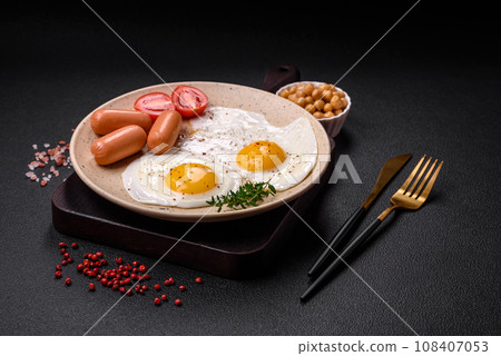 Fried chicken eggs, sausages, cherry tomatoes, chickpeas, spices, salt and herbs 108407053
