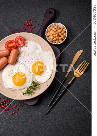 Fried chicken eggs, sausages, cherry tomatoes, chickpeas, spices, salt and herbs 108407055