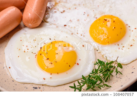 Fried chicken eggs, sausages, cherry tomatoes, chickpeas, spices, salt and herbs 108407057