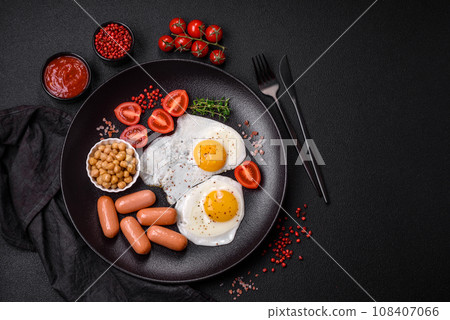 Fried chicken eggs, sausages, cherry tomatoes, chickpeas, spices, salt and herbs 108407066