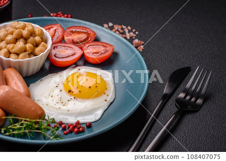 Fried chicken eggs, sausages, cherry tomatoes, chickpeas, spices, salt and herbs 108407075