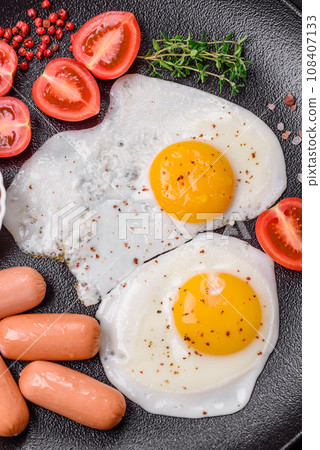 Fried chicken eggs, sausages, cherry tomatoes, chickpeas, spices, salt and herbs 108407133