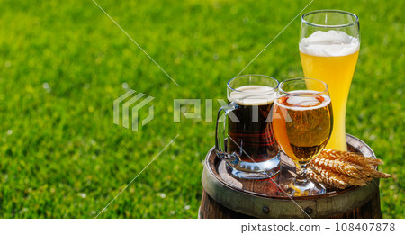 Variety of beer glasses on rustic wooden barrel 108407878