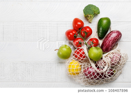 Mesh bag filled with a variety of vegetables Mesh bag filled with a variety of vegetables 108407896