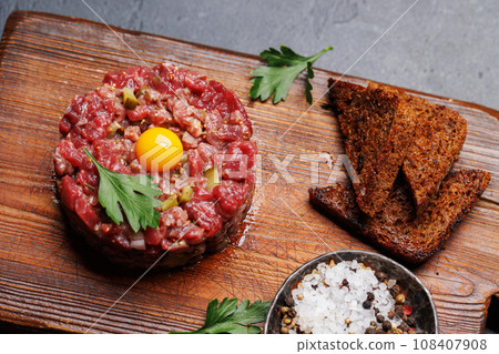 Savory beef tartare and brown bread toasts 108407908