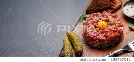 Savory beef tartare and brown bread toasts 108407911