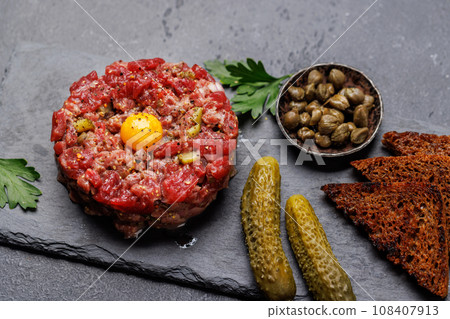 Savory beef tartare and brown bread toasts 108407913