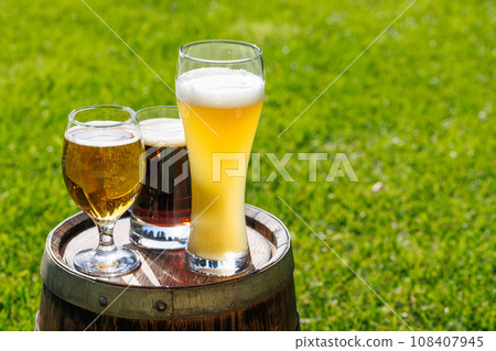 Variety of beer glasses on rustic wooden barrel 108407945