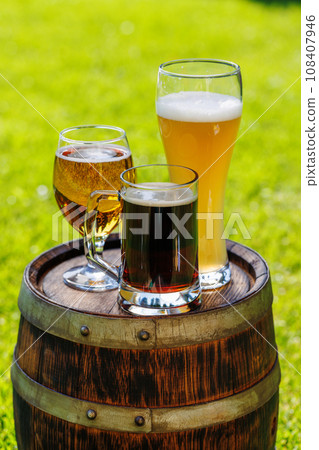 Variety of beer glasses on rustic wooden barrel 108407946
