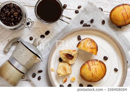 Pasticciotto leccese pastries on a plate near coffee cup and moka on white table top view 108408084