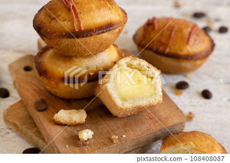 Pasticciotto leccese pastry filled with egg custard cream on a wood close up Pasticciotto leccese pastry filled with egg custard cream on a wood close up 108408087