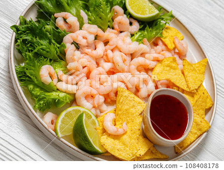 shrimps with lettuce, corn chips, chili sauce 108408178