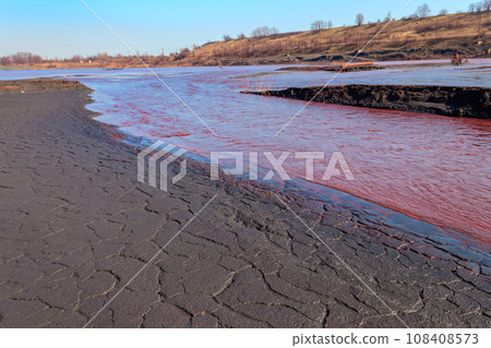 Technical settler of industrial water of mining industry in Kryvyi Rih, Ukraine. Red water polluted with iron ore waste. Discharge of process water in the sump after the iron ore beneficiation Technical settler of industrial water of mining industry in Kryvyi Rih, Ukraine. Red water polluted with iron ore waste. Discharge of process water in the sump after the iron ore beneficiation 108408573