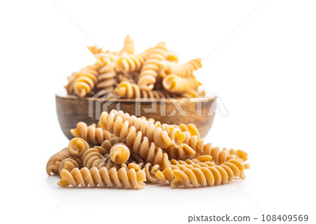 Raw whole grain fusilli pasta. Uncooked pasta isolated on white background. 108409569