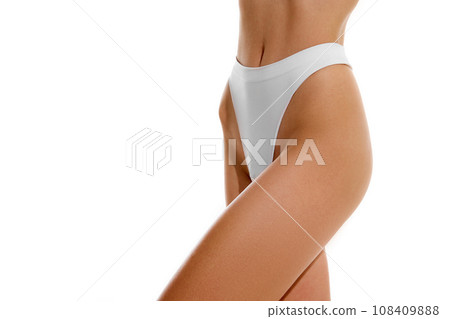 Cropped perfect sporty body shape female body dressed in sensual white lingerie against studio background. Concept of dieting. Cropped perfect sporty body shape female body dressed in sensual white lingerie against studio background. Concept of dieting. 108409888