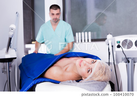 Woman receiving hardware body treatment 108410070