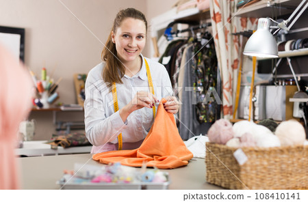 Smiling woman professional working with material at atelier Smiling woman professional working with material at atelier 108410141