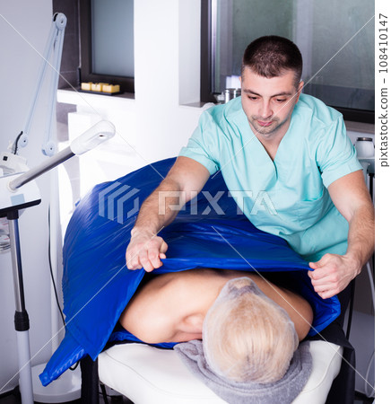 Beautician performing cosmetological procedure 108410147