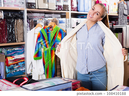 Woman trying on new bathrobe 108410188