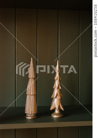 Stylish souvenirs Christmas trees made of ceramics on the field in the decor of the living room Stylish souvenirs Christmas trees made of ceramics on the field in the decor of the living room 108410258