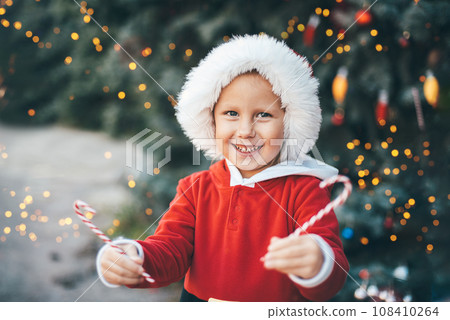 Child waiting for Christmas in wood. portrait of little girl decorating christmas tree. winter holidays and people concept. Happy Holidays. Child waiting for Christmas in wood. portrait of little girl decorating christmas tree. winter holidays and people concept. Happy Holidays. 108410264