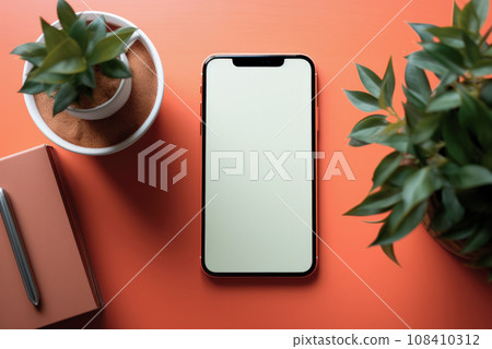 Flat lay mockup of a phone with a white screen on a table with indoor plants, a notebook and a pen 108410312