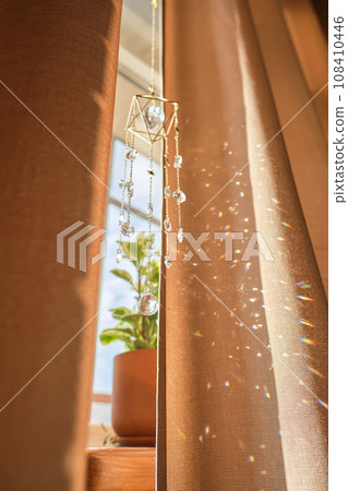 A beige curtain on the window and sunny spots. A beige curtain on the window and sunny spots. 108410446