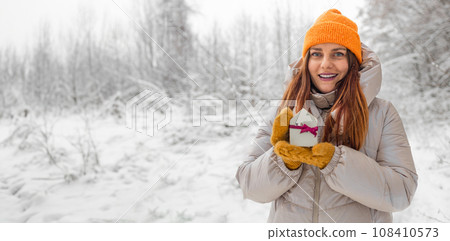 Christmas and New Year miniature house in woman hands outdoors. Copy space for text. Winter card. Holiday and celebration concept.  108410573