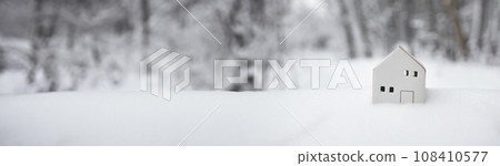 2024 Merry Christmas and happy new year horizontal banner with small toy model house on winter snow background. Miniature white toy house model  108410577