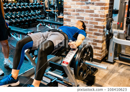 A man receiving guidance from a trainer at a fitness gym 108410623