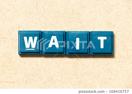 Tile alphabet letter in word wait on wood background 108410757