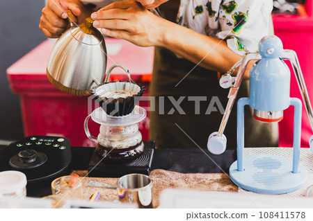 Professional barista preparing coffee using chemex pour over coffee maker and drip kettle. Professional barista preparing coffee using chemex pour over coffee maker and drip kettle. 108411578