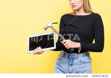 Laptop Repair. Female with hammer and laptop on yellow background Laptop Repair. Female with hammer and laptop on yellow background 108411625