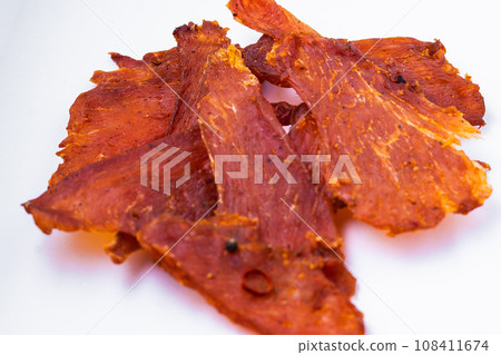 Beef jerky pieces isolated on a white and black background 108411674