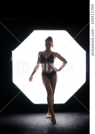 Silhouette of a beautiful young woman wearing underwear in backlight Silhouette of a beautiful young woman wearing underwear in backlight 108411769