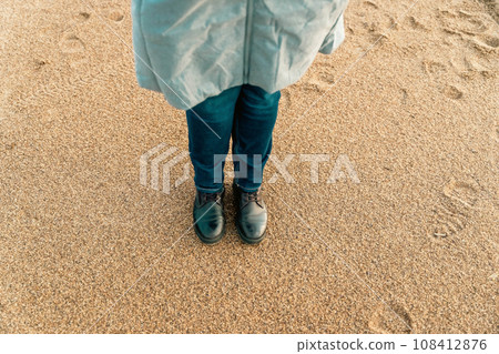 a girl walks on an autumn deserted beach.  108412876