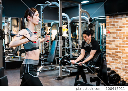 Men and women training at the fitness gym Men and women training at the fitness gym 108412911