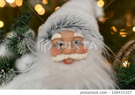 Santa Claus standing under the Christmas tree Santa Claus standing under the Christmas tree 108415107