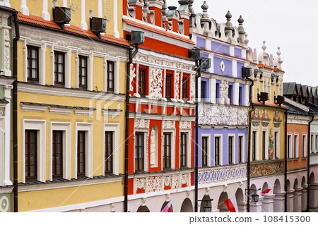 Richly decorated old Renaissance houses in the Polish town of Zamosc. Colorful old European houses, tourist attraction. Brightly painted facades of houses. 108415300