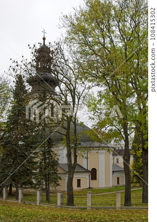 Roman Catholic Church of St. Nicholas, Zamosc. Old catholic church surrounded by autumn trees, landscape. 108415302