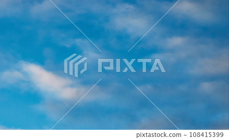 A blue sky with fluffy white cumulus clouds, creating a serene and peaceful atmosphere. The sky with beautiful fluffy clouds, behind which the sun hid. A blue sky with fluffy white cumulus clouds, creating a serene and peaceful atmosphere. The sky with beautiful fluffy clouds, behind which the sun hid. 108415399