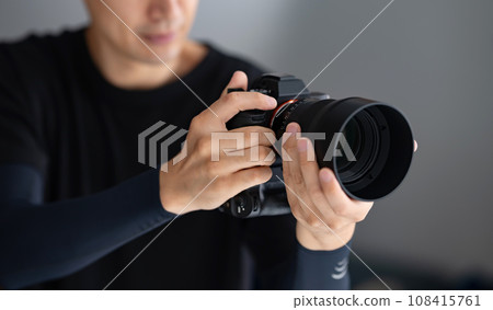 A man holding a camera 108415761