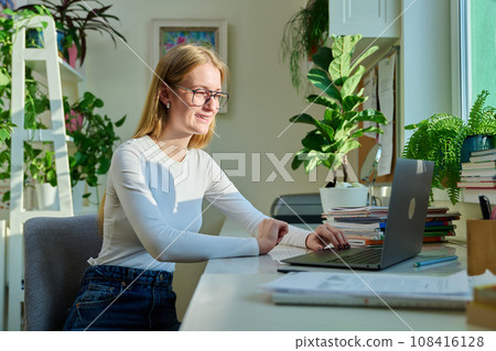 Teenage girl high school student having video conference on laptop 108416128